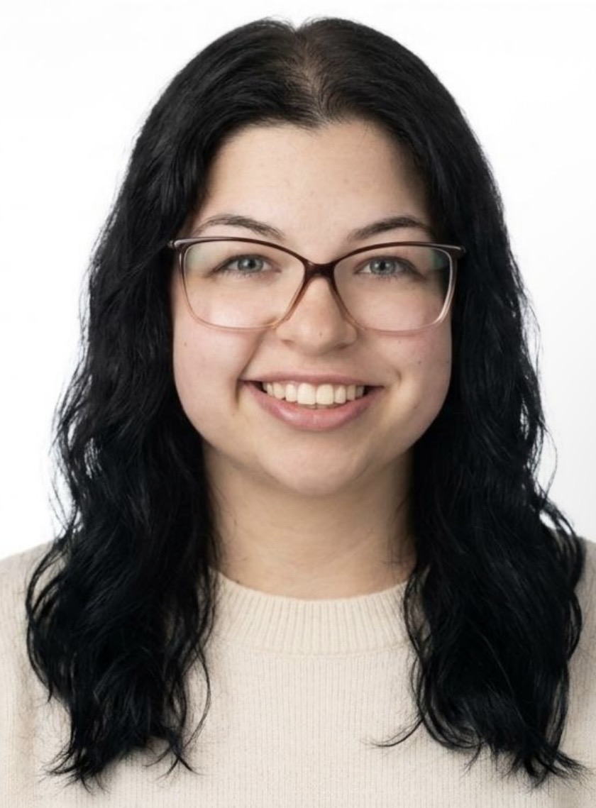 Screenshot - Caring Clarity Counseling - Caring Clarity Counseling Smiling Woman with Long Dark Hair and Pink Glasses, Wearing a Beige Sweaters in a Head-and-shoulders Portrait.